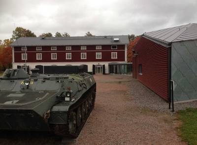 Röd byggnad med stridsvagn utanför